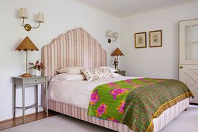 country bedroom with upholstered headboard and colorful duvet