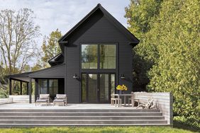 black home exterior with wooden deck