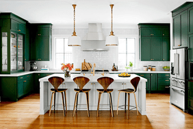 modern kitchen with green cabinets and light pendants over island