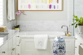 neutral bathroom with large statement art above tub