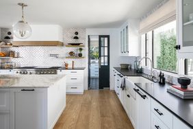 white kitchen with wood floors and scalloped backsplash tile