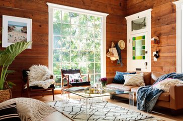 Living room with wood walls and a large window