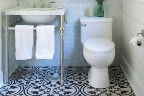 white toilet and marble sink in tiled bathroom