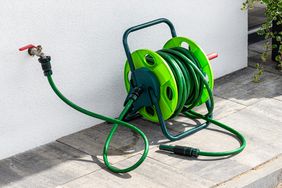 garden house connected to faucet outside on deck