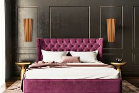 moody bedroom with purple bed frame and pleated sconces