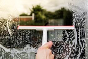 washing windows with squeegee and soap