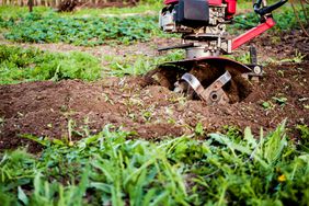 close up of garden tiller turning soil