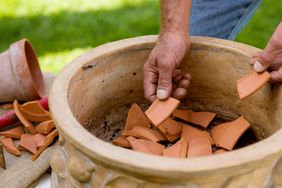 adding terracotta pot shards to bottom of planter 