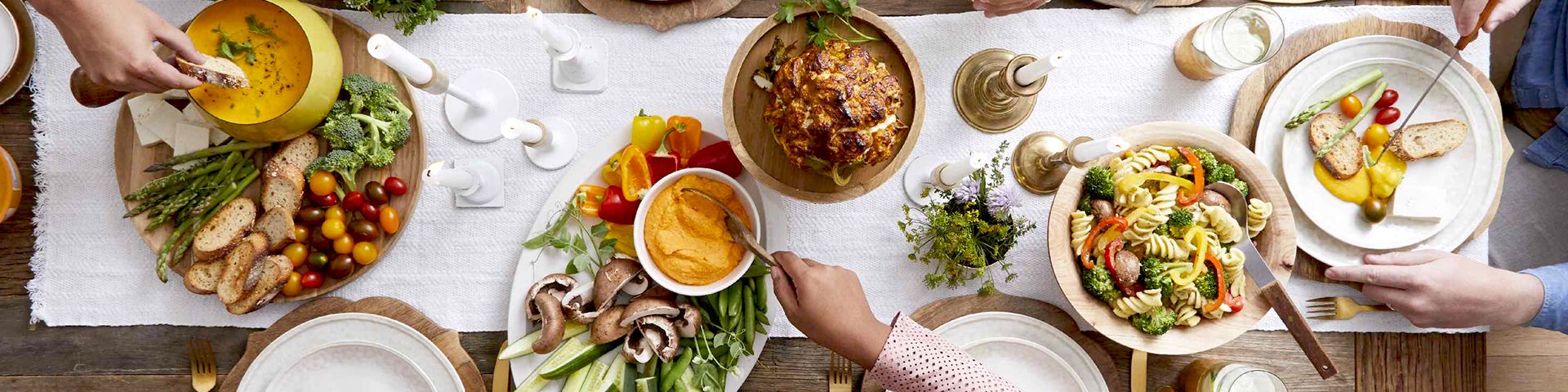 Overhead of a dinner table with hands serving food