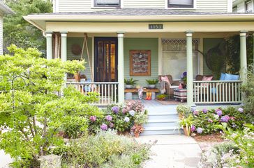 Front of a house with flowers and a porch swing