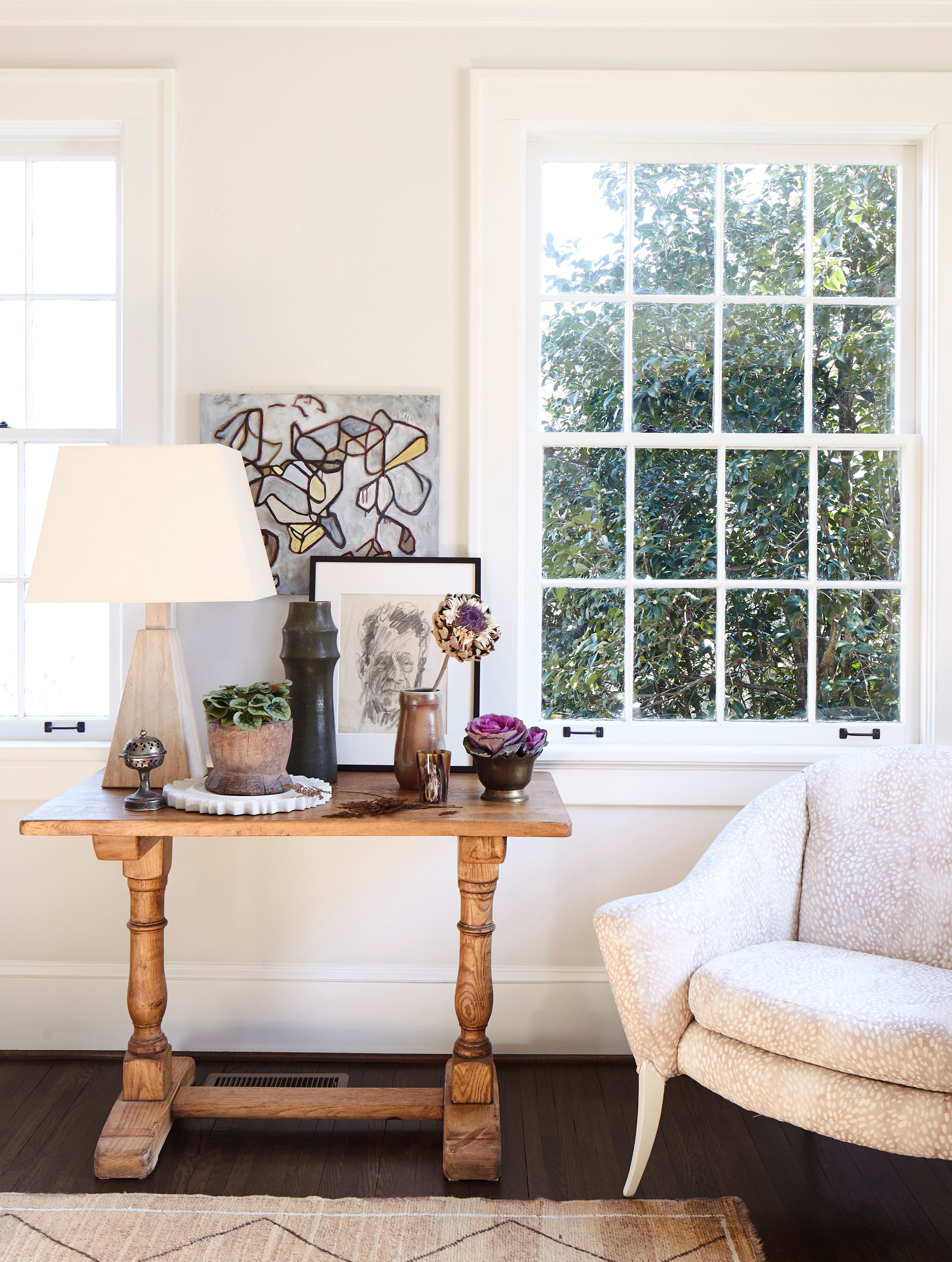 wood table with art next to white chair