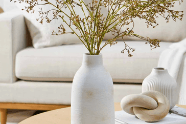 brushed wash white ceramic vase sitting on table with flowers inside