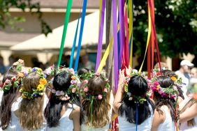 Girls with ribbons around a May Day pole