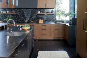 black and brown kitchen with black marble backsplash