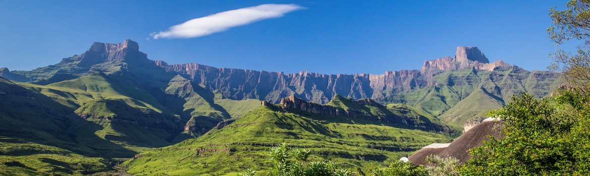 Nationalpark mit Wiesen im Vordergrund und gebirgsartigen Randstufe im Hintergrund ohne Pflanzenbewuchs, die sich quer durchs Bild zieht