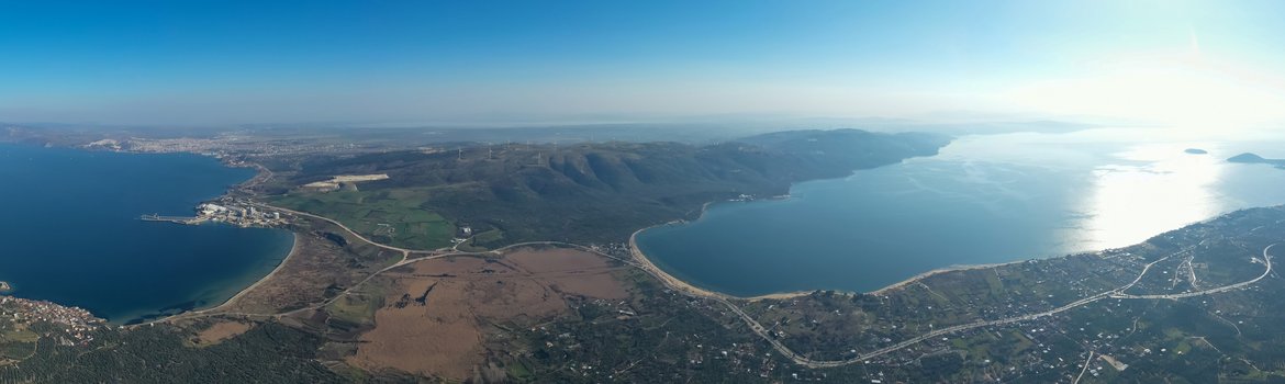 Luftaufnahme aus ca. 500m Höhe. Ansicht der Halbinsel aus Richtung Festland. Der schmale Übergang mittig, rechts und links das Meer und am Horizont die Halbinsel. Darüber blauer Himmel.