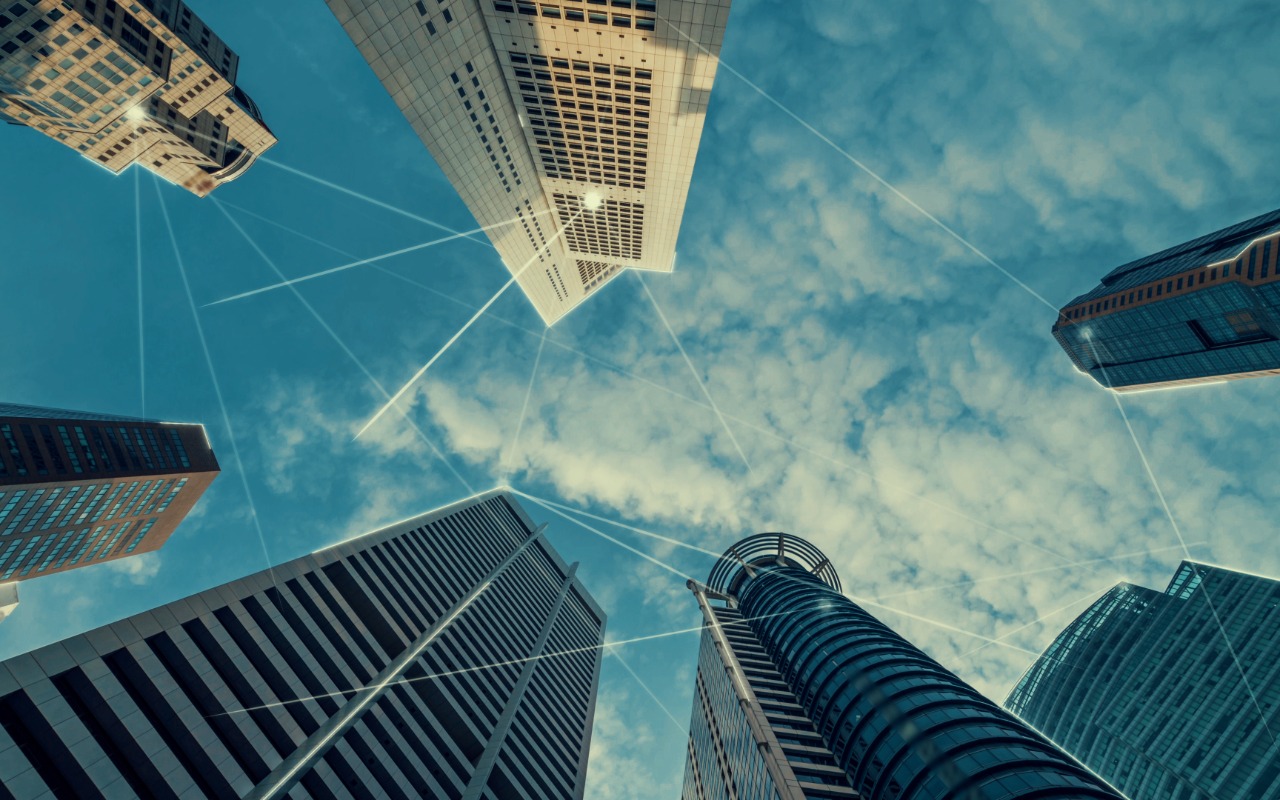 Skyscrapers as seen from looking up at ground level, with connections indicating Internet and digital network connectivity between buildings.