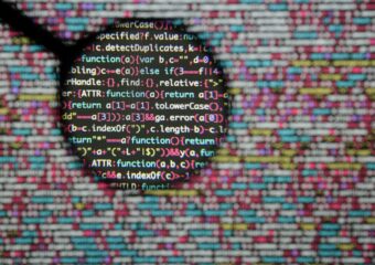 Closeup of programming code and a magnification of lines looking for malicious coding.