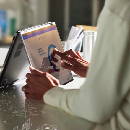 Woman reviewing data on Dell APEX platform on a Dell Latitude 9430 2-in-1 laptop.