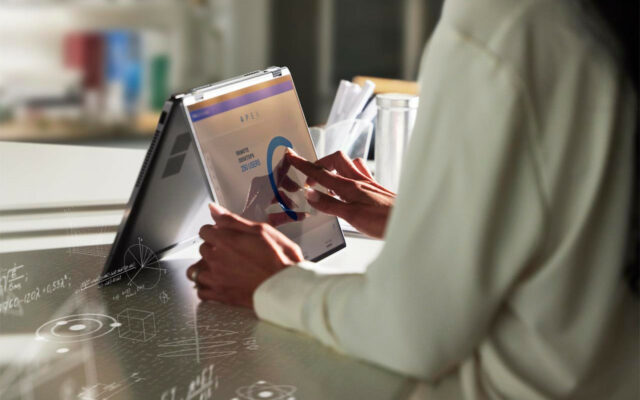 Woman reviewing data on Dell APEX platform on a Dell Latitude 9430 2-in-1 laptop.