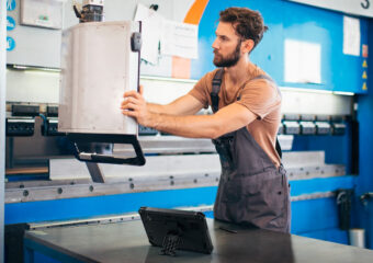 Fabrication Specialist reviewing data with Dell Latitude Rugged 7030, connected to company's infrastructure using Dell APEX Cloud Platform.