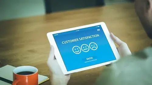 Person looking at a tablet rating their customer satisfaction through an online survey.