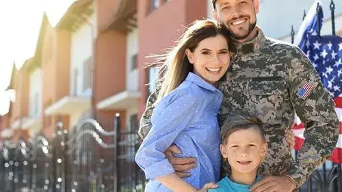 Family standing next to one another in front of a house