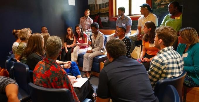 Image of students, faculty, and staff having a discussion