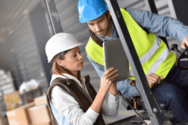 Male and female retail workers looking at a tablet in an inventory room