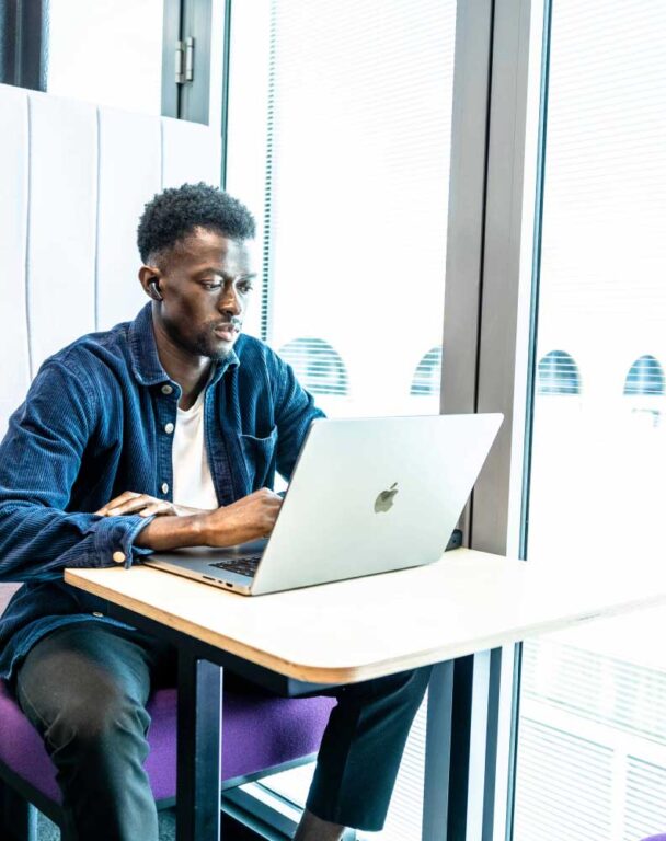 Man working by a window on a laptop