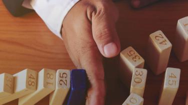  A hand lining up numbered blocks representing various risks companies face when selling outside of Canada