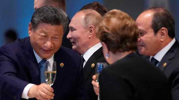 Chinese President Xi Jinping, left, and Dilma Rousseff, chair of the New Development Bank, clink glasses&nbsp;at a reception to mark the BRICS summit in Kazan, Russia, on&nbsp;Oct. 23. Russian President Vladimir Putin is at center. (Pool photo via Reuters)&nbsp;