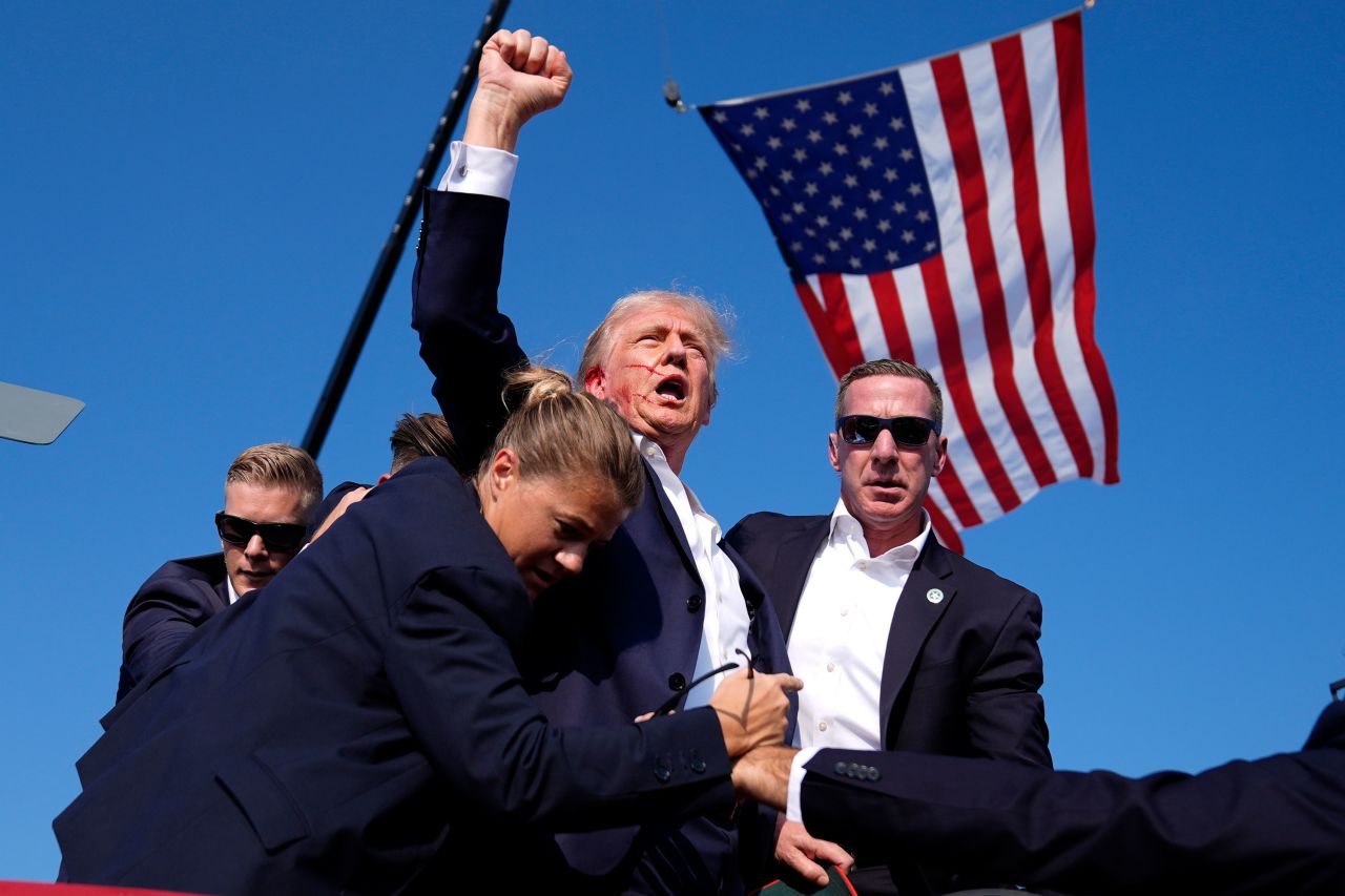 Donald Trump: “Fight!”: Donald Trump gets back up after assassination attempt. Fist in the air, shouts “Fight!” Photograph by Evan Vucci.; assassination; President Donald Trump; Trump rally; President Donald Trump; assassination; Orwellian