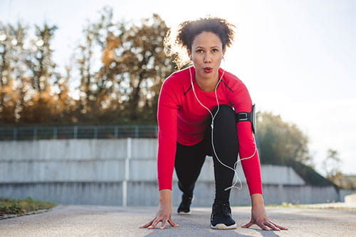 young woman in runners starting position