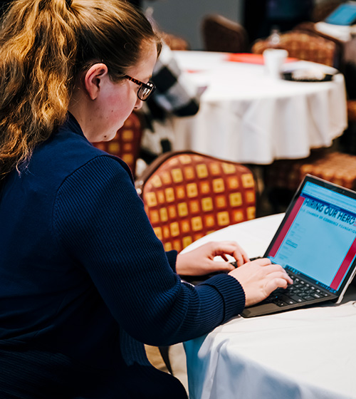 Woman working on a laptop submitting information on the Hiring Our Heroes website.