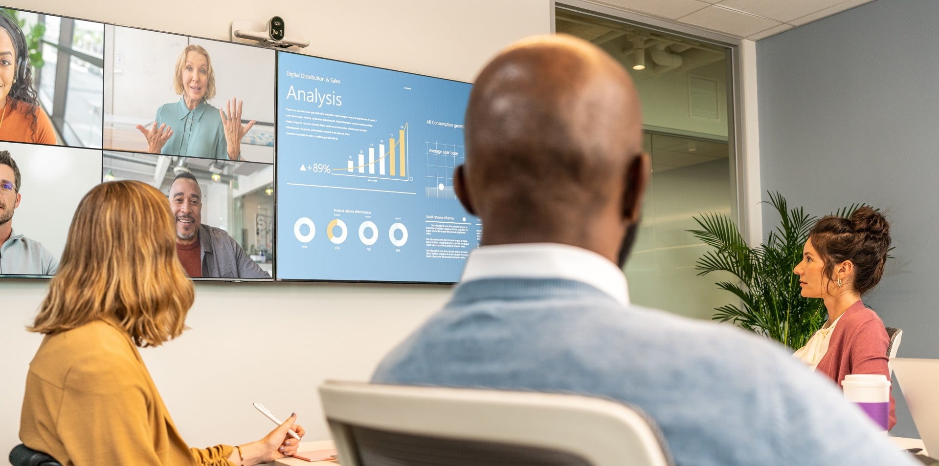 People in large conference room during a video call using Poly Studio E70 pc-based video conferencing camera