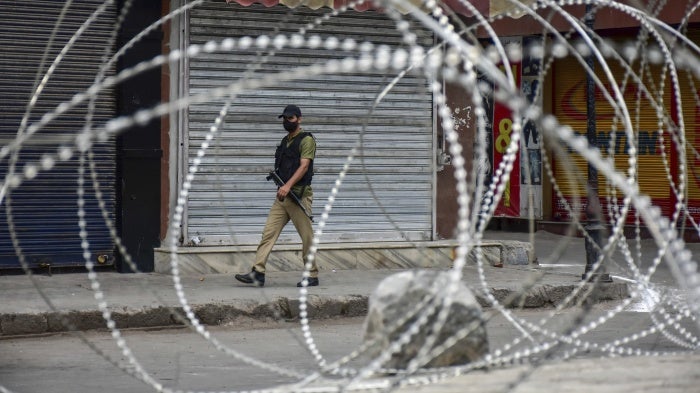 A paramilitary trooper patrols along a deserted road during India's Independence Day celebrations in Srinagar, in Jammu and Kashmir, August 15, 2021.