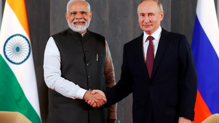 Russian President Vladimir Putin, right, and Indian Prime Minister Narendra Modi pose for a photo shaking hands prior to their talks on the sidelines of the Shanghai Cooperation Organisation (SCO) summit in Samarkand, Uzbekistan, on Sept. 16, 2022.