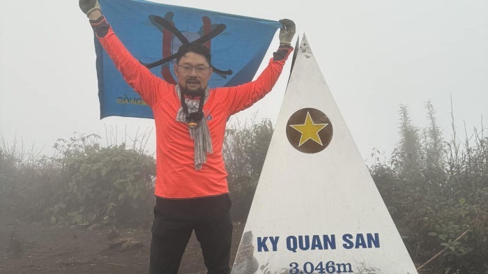 Nguyen Chi Tuyen carries a No-U banner (No to China’s Nine Dash Line) at Ky Quan San Peak, Vietnam.