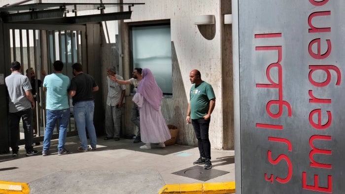 People stand outside a hospital emergency room