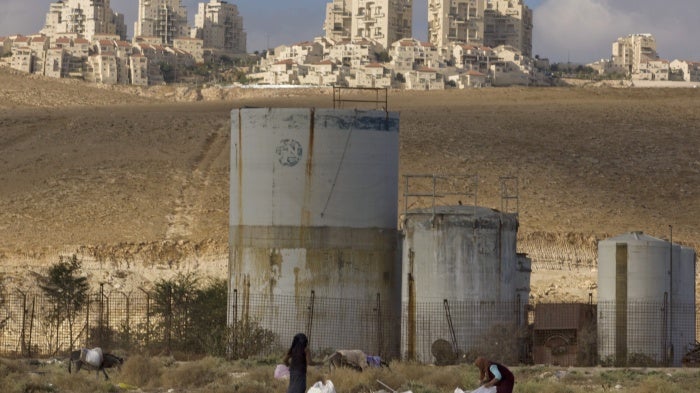 People collect scrap timber in the Mishor Adumim industrial zone near the Israeli settlement of Maaleh Adumim, November 22, 2010.