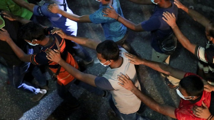 Undocumented migrants walk in line while being detained during an immigration raid in Kuala Lumpur, Malaysia, July 1, 2022.