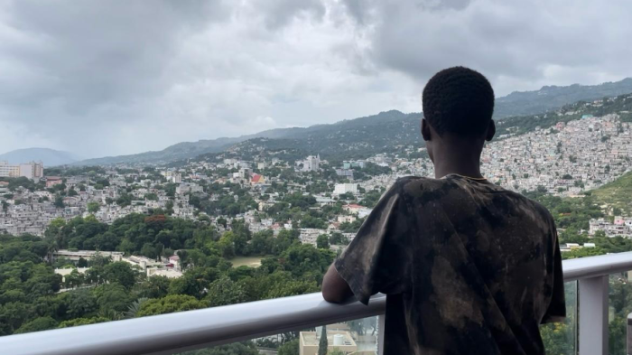 A 17-year-old Carrefour resident, associated with a criminal group, stands on a terrace, gazing out over the horizon in Port-au-Prince, Haiti, July 2024.