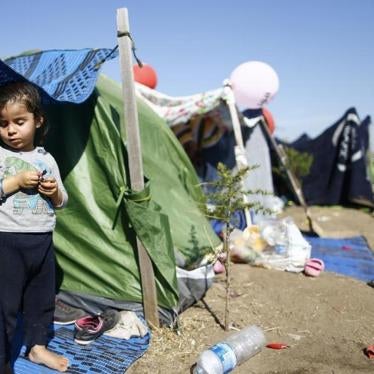 A migrant child stands in a tent on the side of a highway near Edirne, Turkey where hundreds of mostly Syrian migrants have had to wait as Turkish police prevent their bid to cross the border with Greece. 