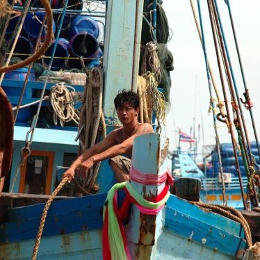 A fisher at the prow of a boat, mooring rope in hand, as the vessel arrives in port in Pattani, August 12, 2016.