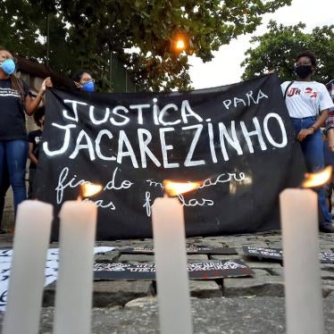 Activists hold a sign that reads in Portuguese "Justice for Jacarezinho. End massacres in favelas" during a protest a day after police killed 27 people during an operation in Jacarezinho favela, in Rio de Janeiro, Brazil, on May 7, 2021. 