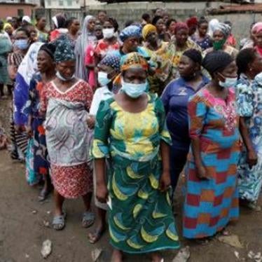 Women queue for food parcels during distribution by volunteers of the Lagos Food Bank Initiative, a nongovernmental organization, in a community in Oworoshoki, Lagos, Nigeria.