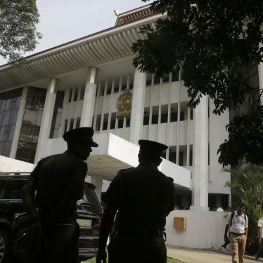 Police officers stand in front of a building.