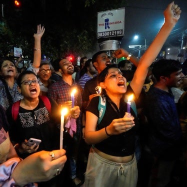 Protesters hold signs and candles 