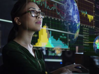 A stock trader reviews stock market data on a monitor